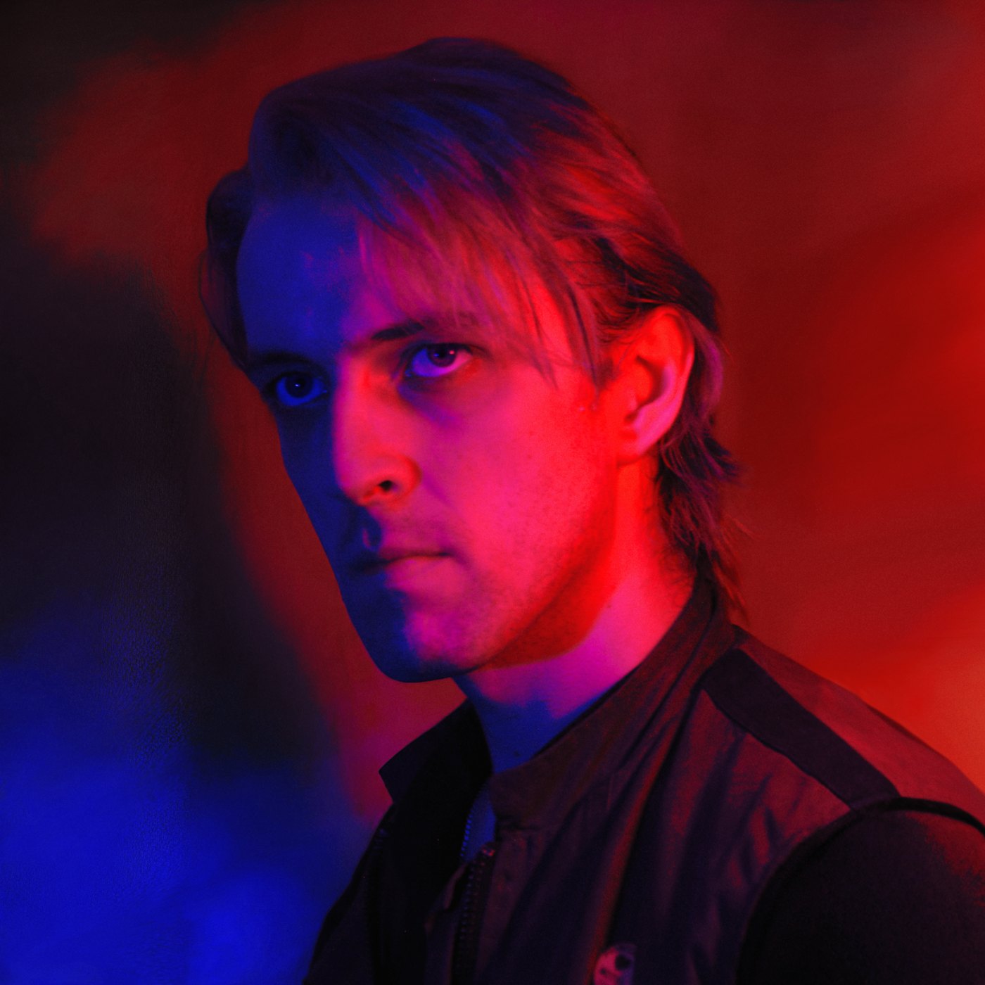 Portrait of Jak Vanson in red and blue light